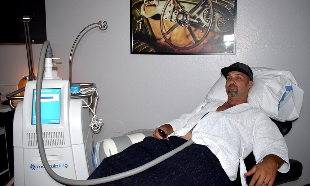 Man relaxing while receiving body contouring treatment for men at Admire Aesthetics inside the man cave treatment room.