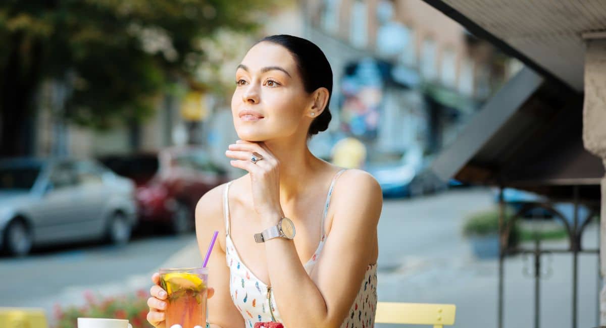 a lovely lady revealing her chin while holding it in her left hand