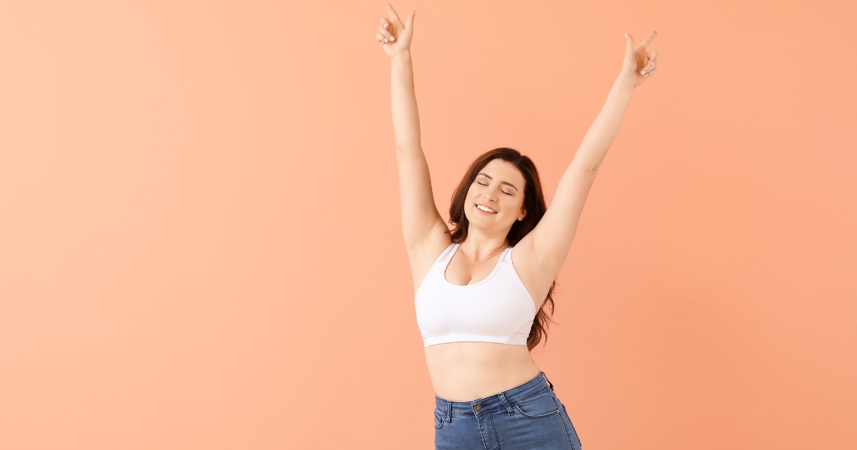 a fatty woman woman raises both hands with confidence and joy