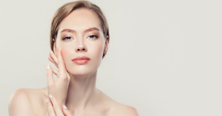 1A. Admire Aesthetics Logo Gold Arrow & White Woman with smooth, youthful skin gently touching her cheek against a neutral background.